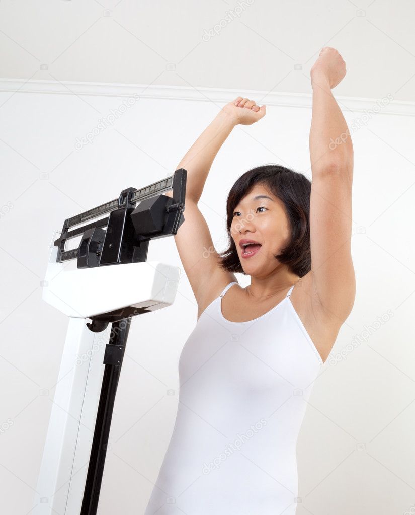 Happy Woman on Weight Scale Cheering