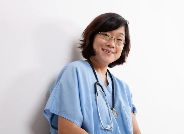 Usmívající se žena lékař nebo zdravotní sestra v modré křoviny — Stock fotografie