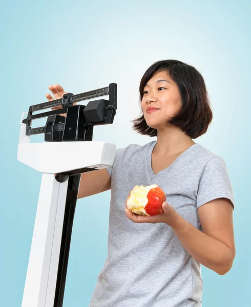 Žena s apple o hmotnosti na stupnici — Stock fotografie