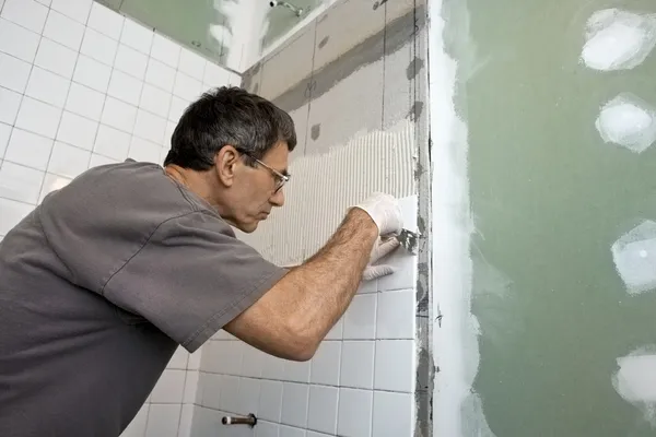 Homem amarrando uma parede do banheiro — Fotografia de Stock