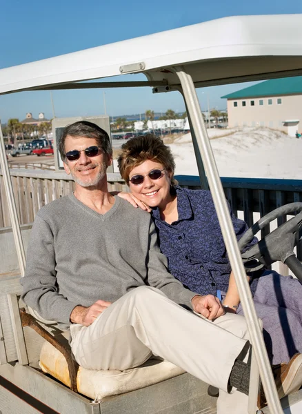 古いゴルフのカート浜で引退したカップル — ストック写真