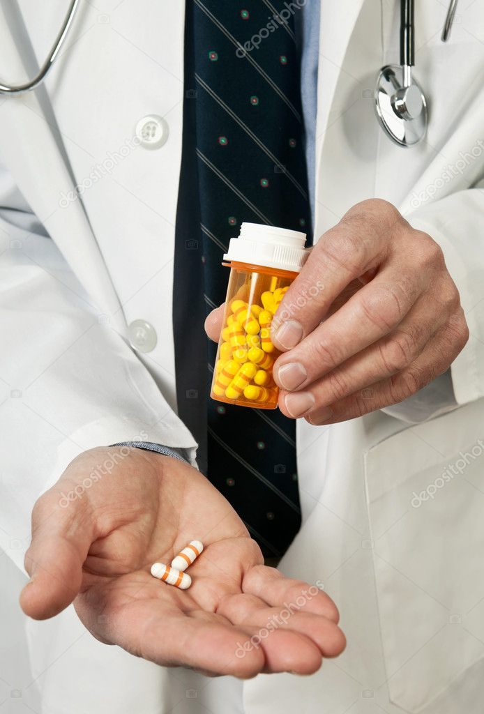 Doctor Holding Pills in Hand Closeup