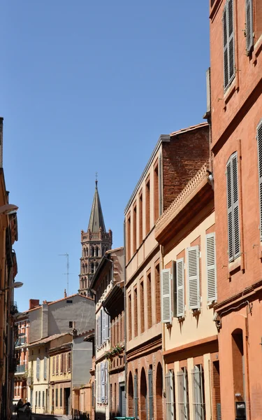 Toulouse v jižní Francie s typickou architekturou z červených cihel proti jasně modré obloze - st sernin bazilika — Stock fotografie
