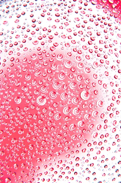 Water druppels op glas rode en witte kleur Stockafbeelding