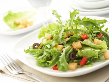 Green salad with restaurant setting clipart