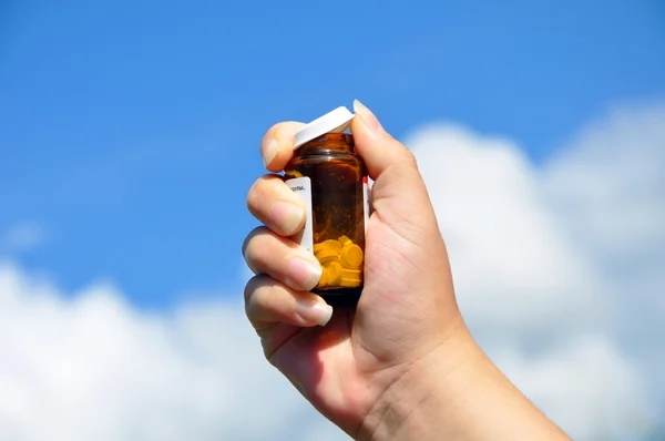 Frasco de pastillas en la mano de una mujer —  Fotos de Stock