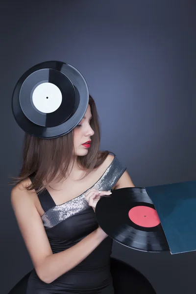 Girl with a vinyl record on a dark background — Stock Photo, Image