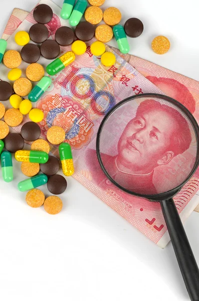 Chinese currency and medicine with magnifier — Stock Photo, Image