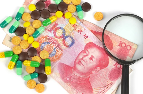 Chinese currency and medicine with magnifier — Stock Photo, Image