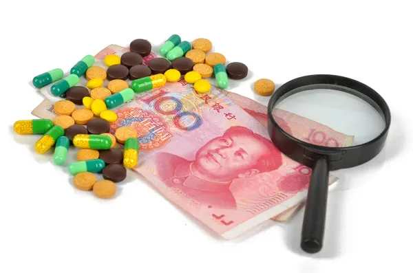 stock image Chinese currency and medicine with magnifier