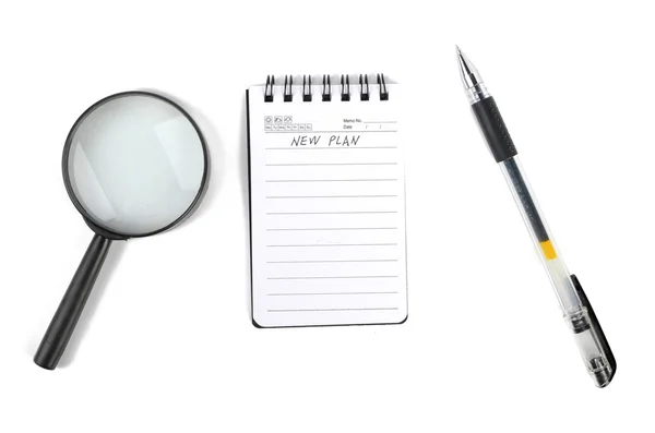 Magnifier and notepad with pen — Stock Photo, Image