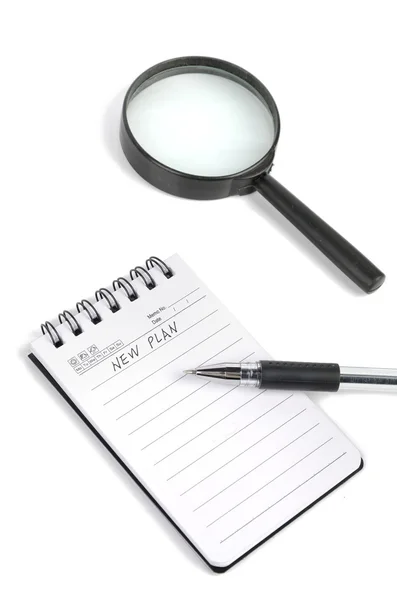 Magnifier and notepad with pen — Stock Photo, Image