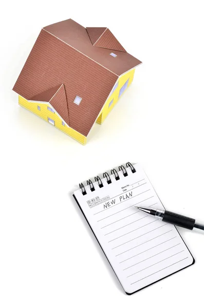 Model house and notepad with pen — Stock Photo, Image