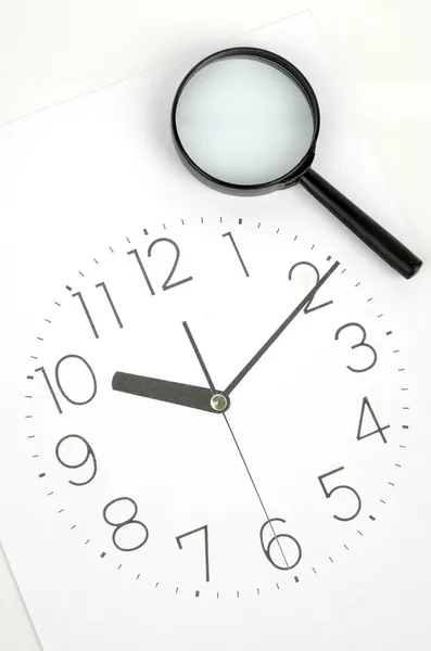 Relógio rosto e lupa — Fotografia de Stock