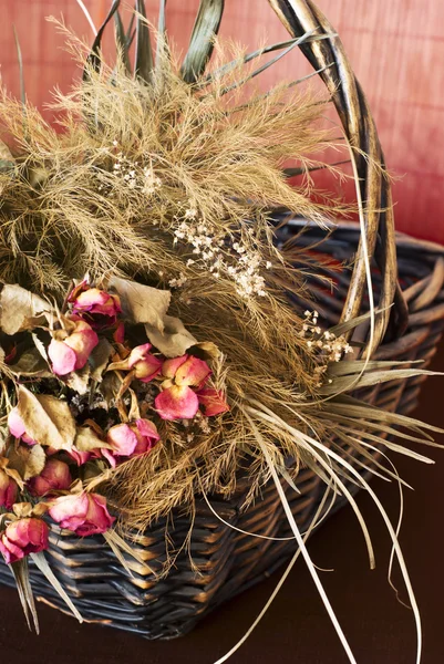 Arrangement of dried roses in a basket — Stock Photo, Image