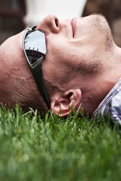 Człowiek leżący na trawie — Zdjęcie stockowe