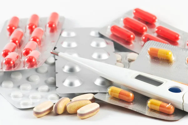 Médicaments, pilules pharmaceutiques un thermomètre — Photo