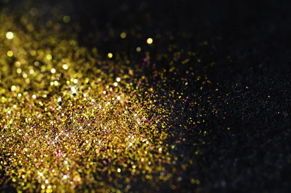 Gold glitter on black background — Stock Photo, Image