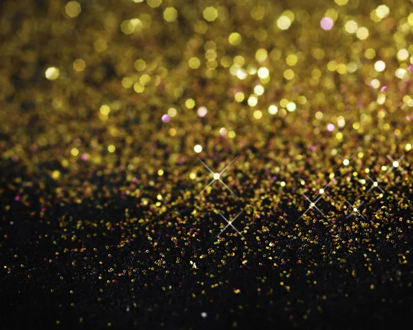 Guld glitter på svart bakgrund — Stockfoto