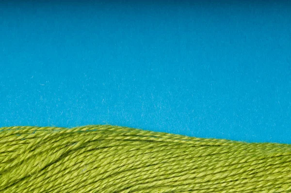 Зелена нитка з синім фоном — стокове фото