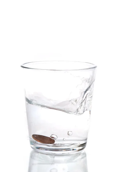 Glas vatten med ett mynt — Stockfoto