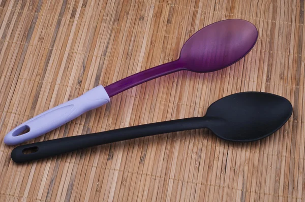 Фиолетовая и черная ложка на кухне — стоковое фото