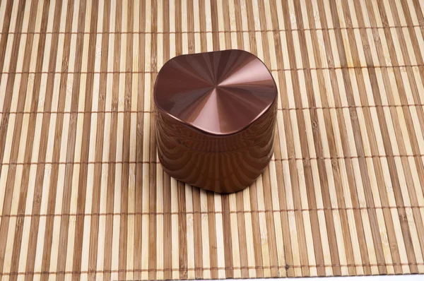 Boîte à crème fermée sur le fond en bambou — Photo
