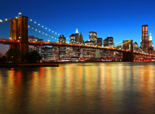 Historic Brooklyn Bridge and lower Manhattan reflected in East River