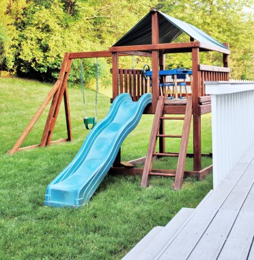 Wooden playset in a backyard clipart