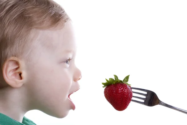 Chlapec jíst jahody — Stock fotografie