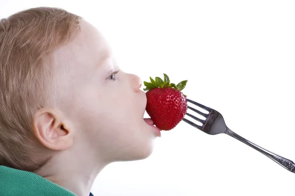 Chłopiec jeść truskawki — Zdjęcie stockowe