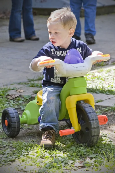 Мальчик на игрушечном велосипеде — стоковое фото
