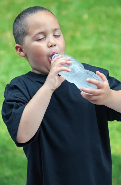 Smiling latino boy drinking water — Stock Photo, Image