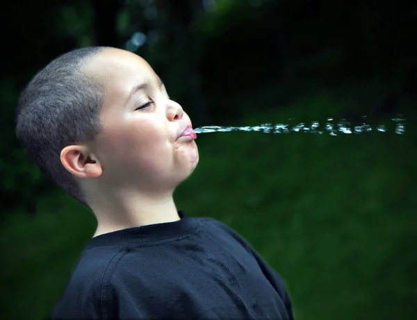 Latino menino cuspir água — Fotografia de Stock