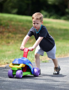 Boy pushing toy bike