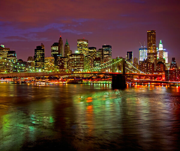 Historic Brooklyn Bridge and lower Manhattan reflected in East River