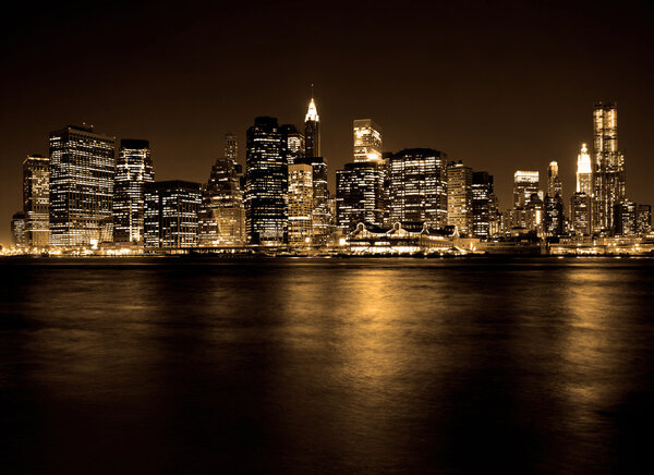 Lower Manhattan in New York City at night with reflection in water
