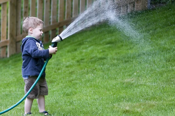 Chlapec zalévání zahrady — Stock fotografie