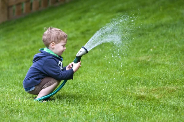 Pojke vattning trädgård — Stockfoto