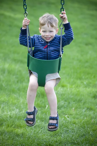 Boy in swing — Zdjęcie stockowe