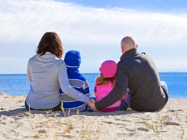 Familj på fyra personer vid stranden — Stockfoto