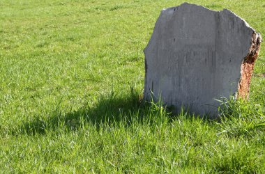 Tombstone on a green lawn clipart