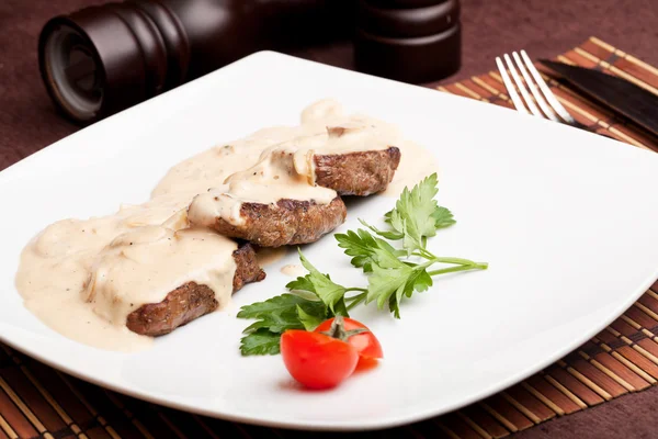 Geroosterd vlees onder witte saus — Stockfoto