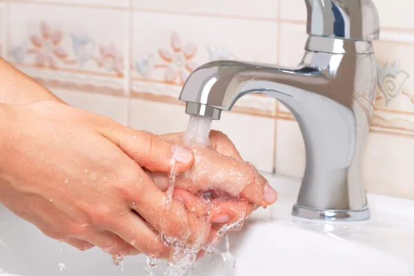 Женщина стирает руки в ванной комнате — стоковое фото