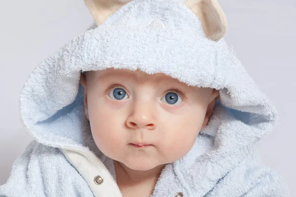 Porträt eines fröhlichen Kindes im blauen Bademantel — Stockfoto