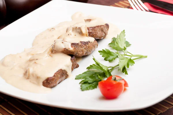 Roasted meat under white sauce — Stock Photo, Image