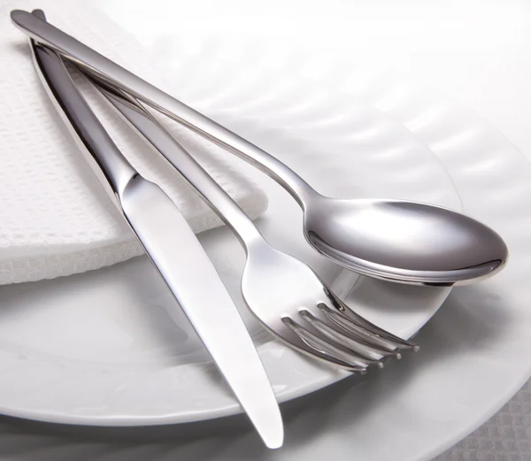 Виделка, ніж, ложка і біла тарілка — стокове фото