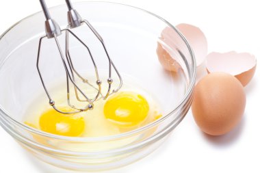 Wire whisk and brown eggs, isolated on white. clipart