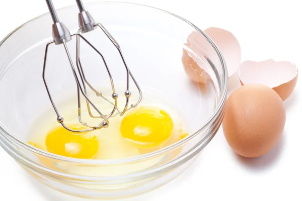 Šlehací metla a hnědých vajec, izolované na bílém. — Stock fotografie