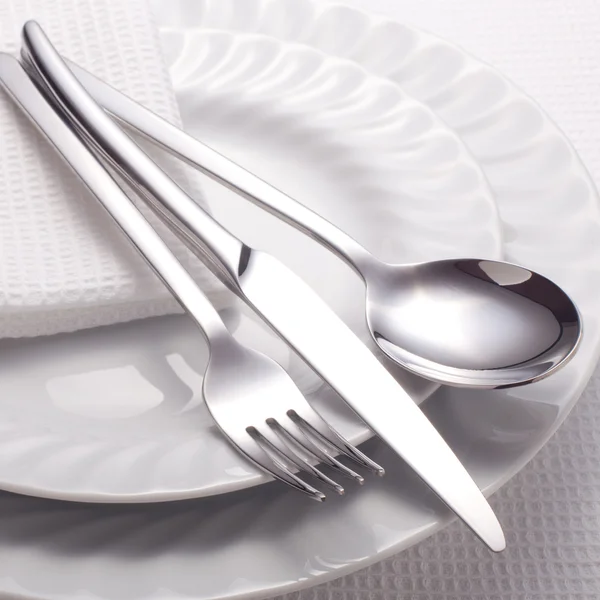 Виделка, ніж, ложка і біла тарілка — стокове фото